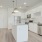 Spacious and well lit kitchen with wood flooring and stainless steel appliances