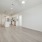 Spacious and well lit living room with wood flooring, large windows and open access to the kitchen
