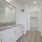 Large well lit bathroom with white accents 