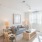 A living space with sofa, chairs, coffee table, and entertainment center at The Chloe apartments in Kyle, TX.