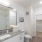 A spacious, brightly-lit bathroom with vanity sink, cabinets, and walk-in closet at The Chloe apartments in Kyle, TX.